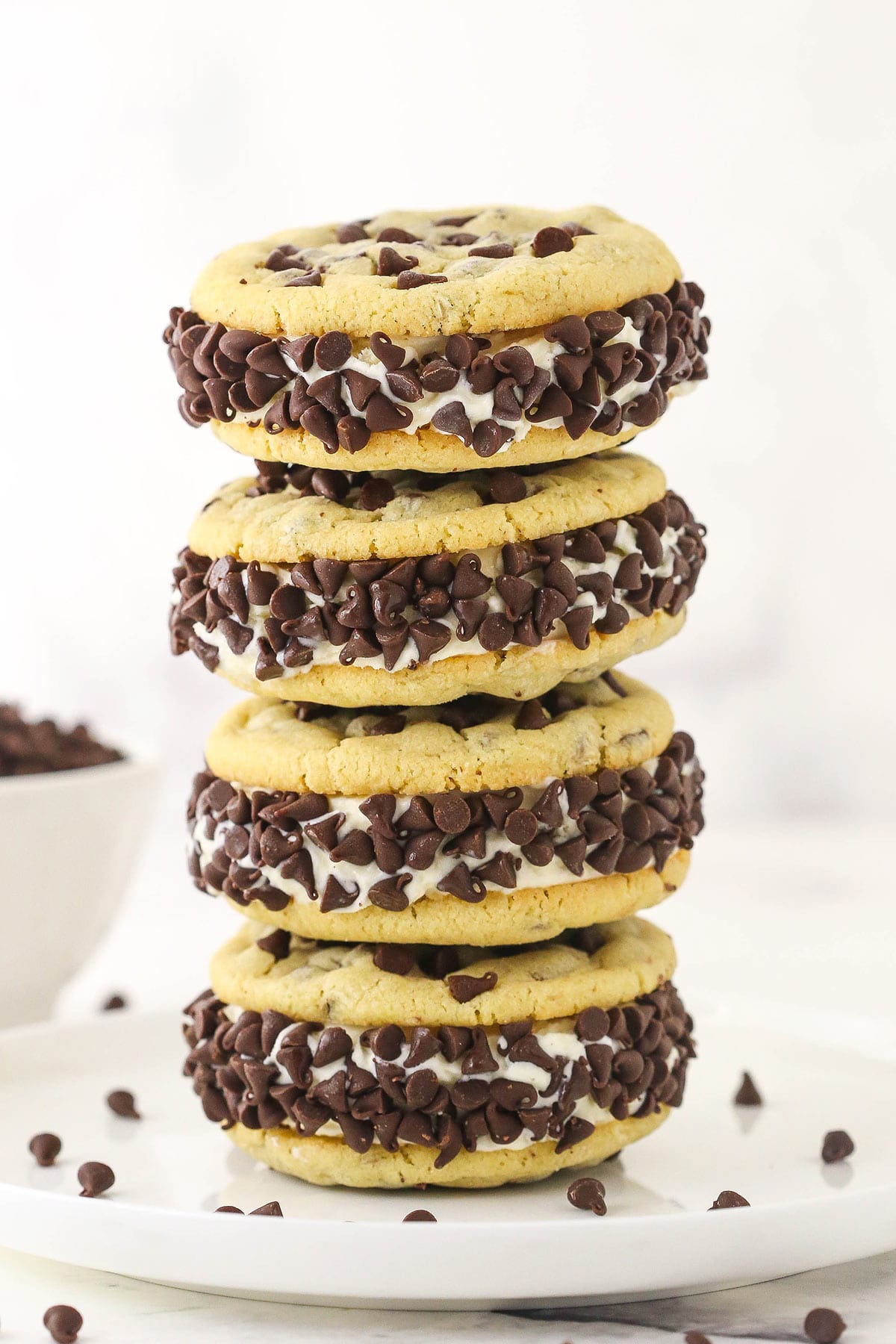 A stack of four ice cream cookie sandwiches with mini chocolate chips around the edges