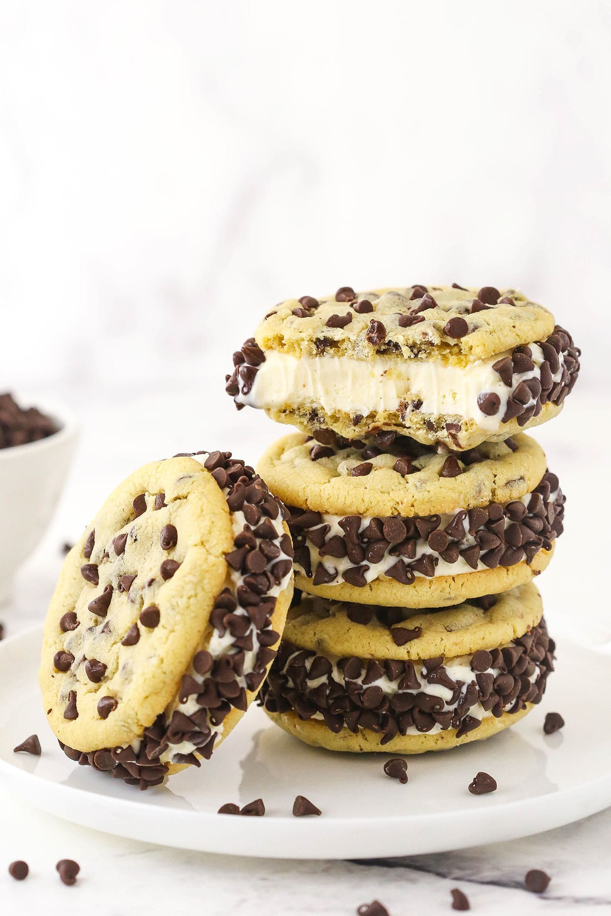 A stack of three chipwiches with the top one missing a few bites and another chipwich propped up against the stack