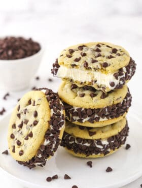 Three ice cream cookie sandwiches stacked on top of one another with a fourth one leaning against the stack