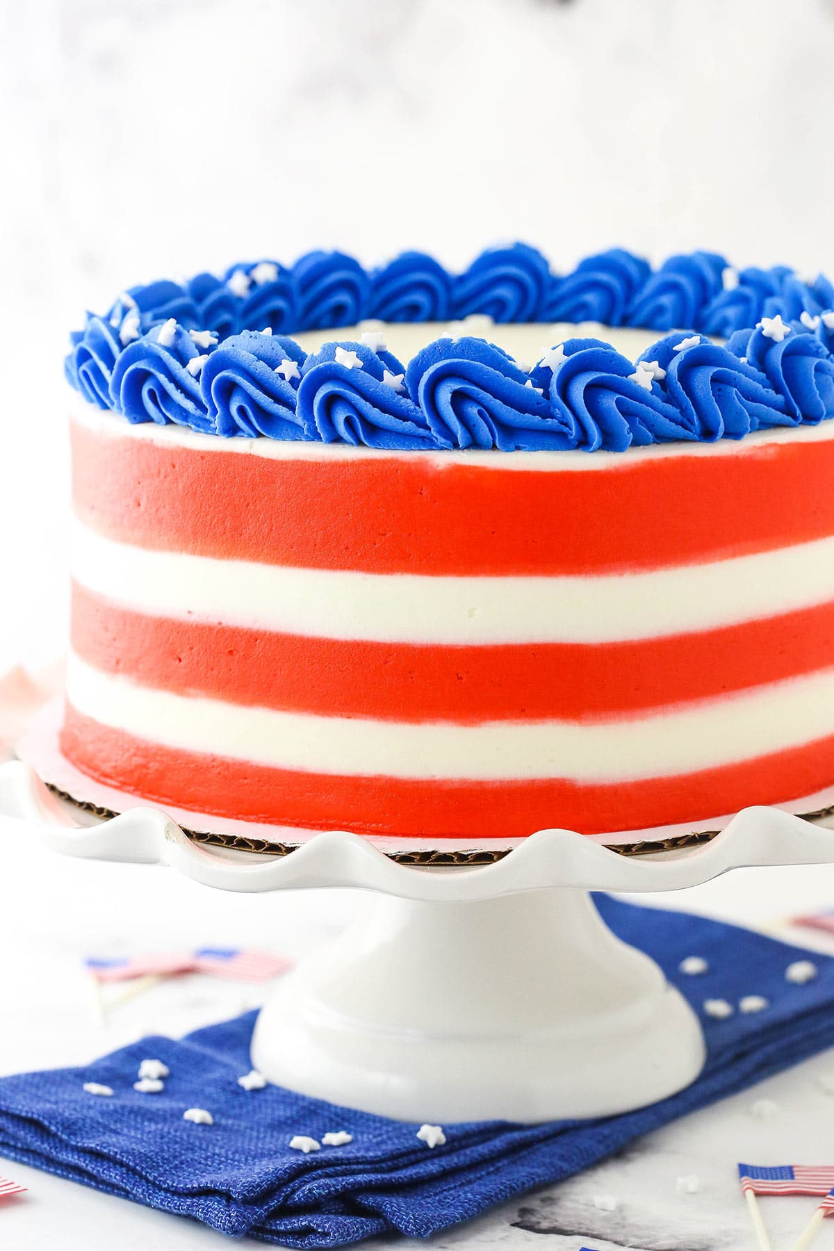 An America-themed marble cake on a plastic cake stand on top of a blue kitchen towel