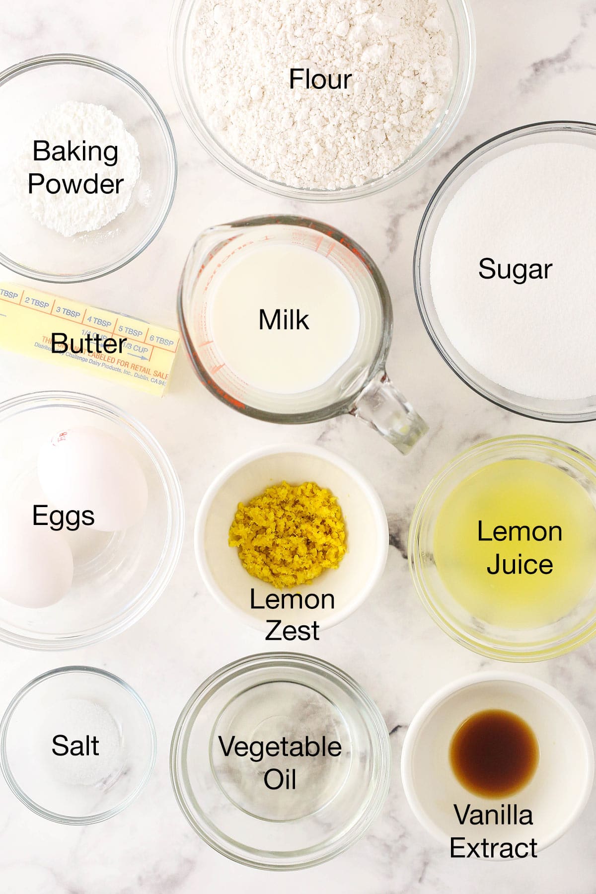 Eggs, vanilla extract, milk, flour and the rest of the breakfast cake ingredients on a kitchen countertop