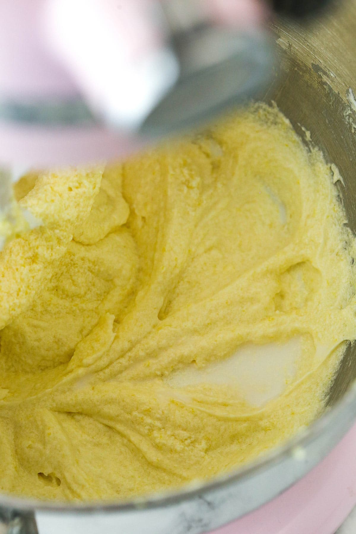 Lemon loaf cake batter in the process of having milk mixed into it