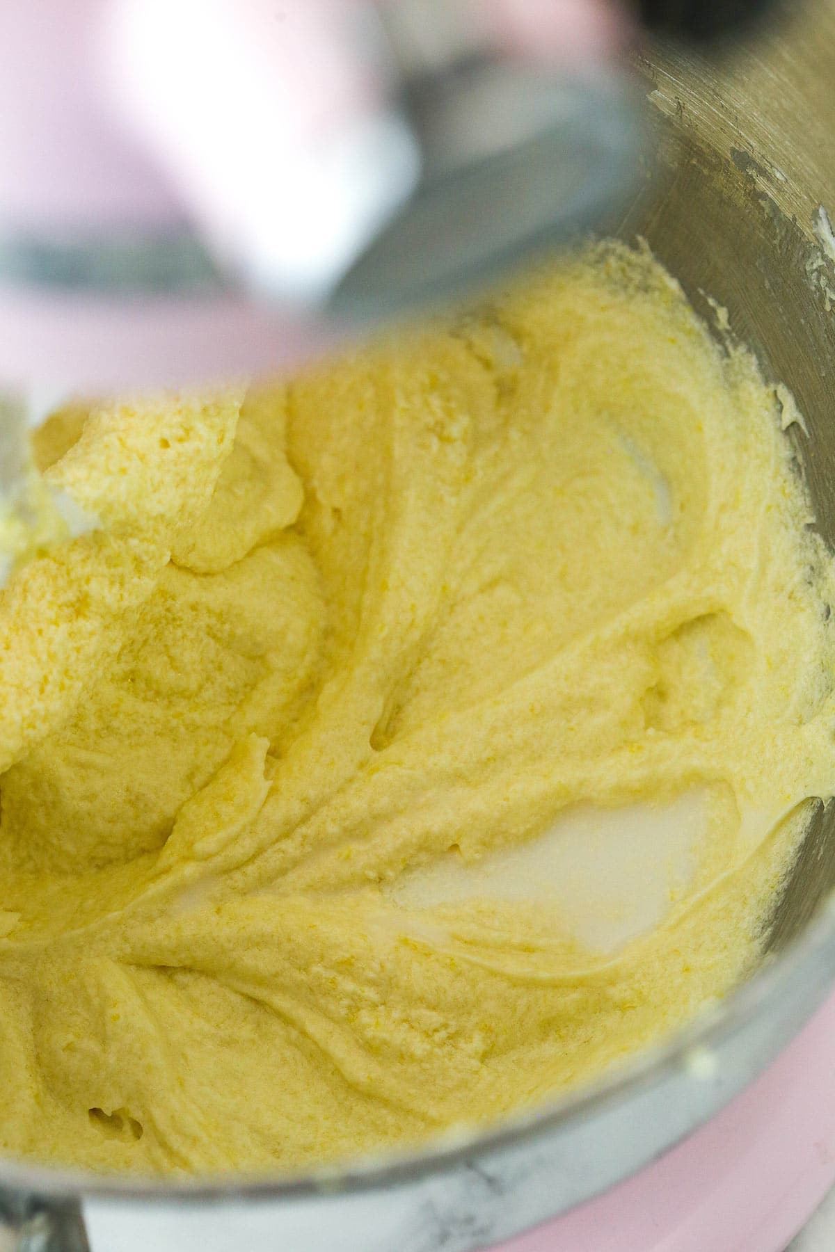 Lemon loaf cake batter in the process of having milk mixed into it