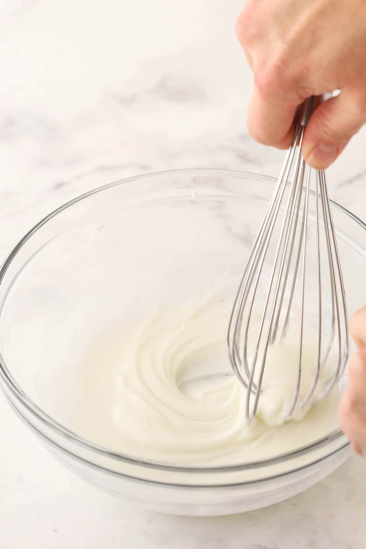 Homemade lemon icing-glaze being whisked in a small mixing bowl