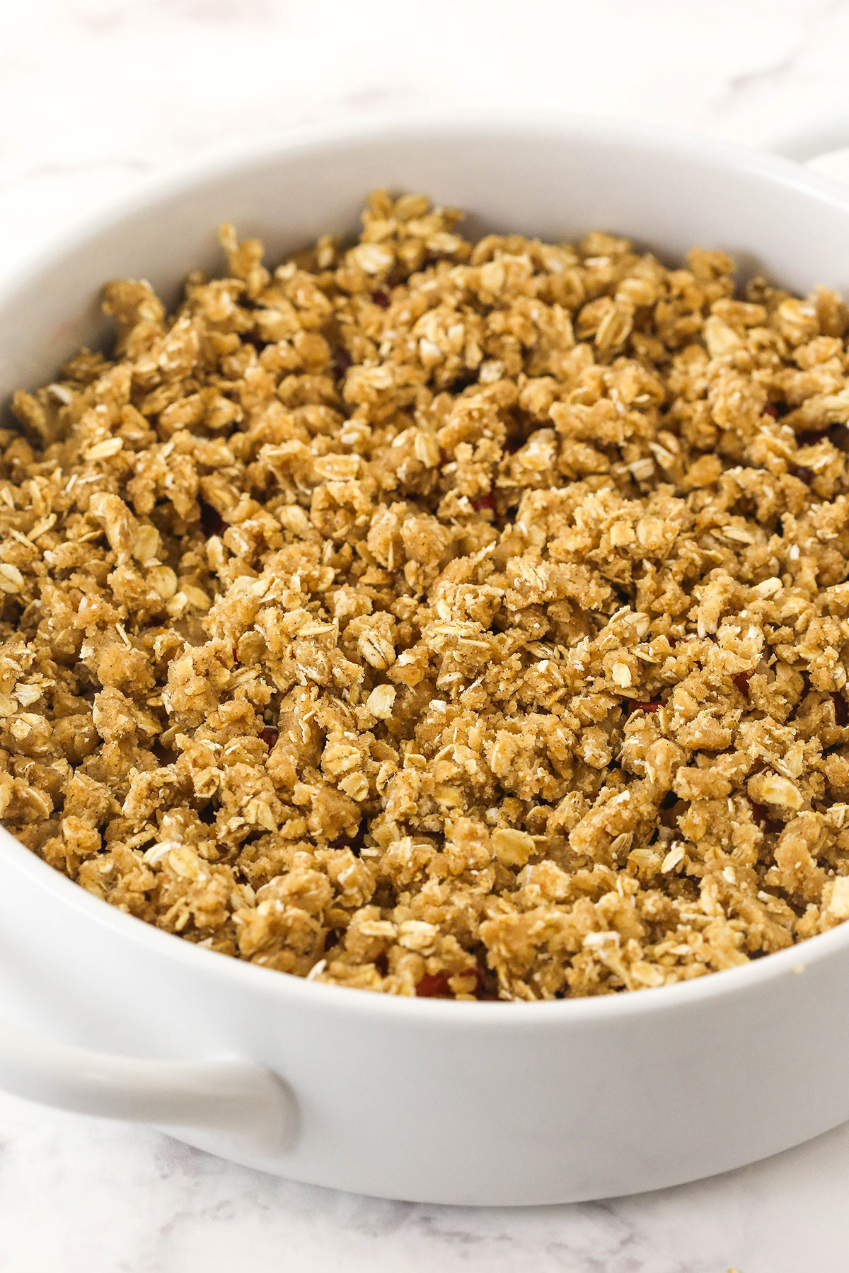 The strawberry rhubarb mixture covered with the crisp topping in a baking dish.