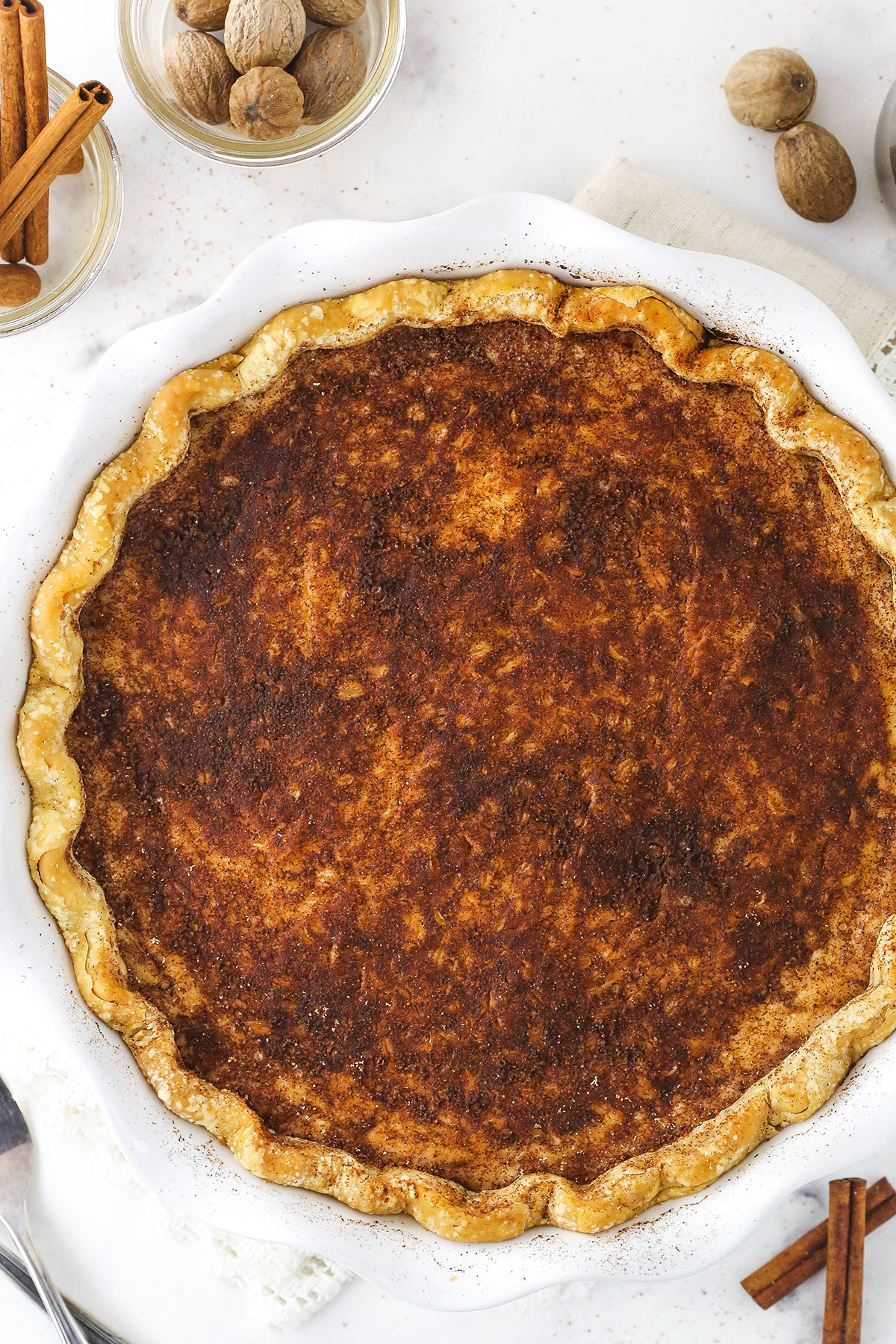 An overhead shot of a sugar cream pie in a pie dish on a kitchen countertop