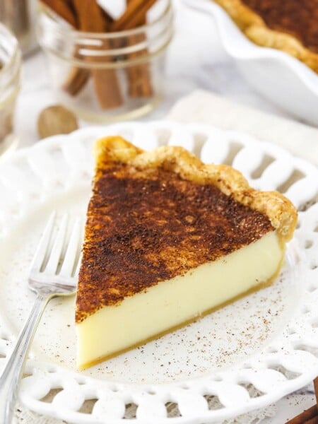 A piece of homemade pie on a small dessert plate with cutouts in the rim