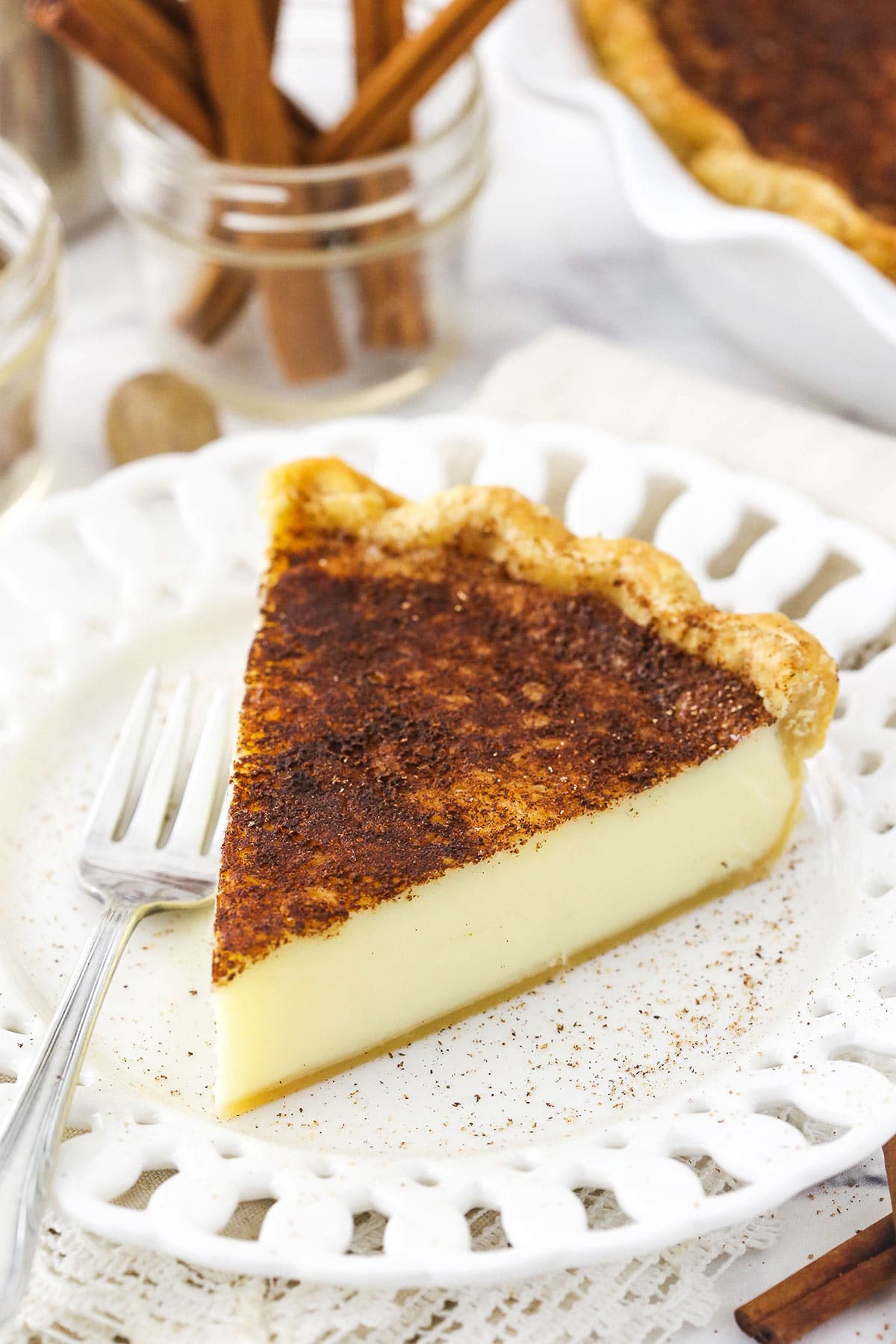 A piece of homemade pie on a small dessert plate with cutouts in the rim