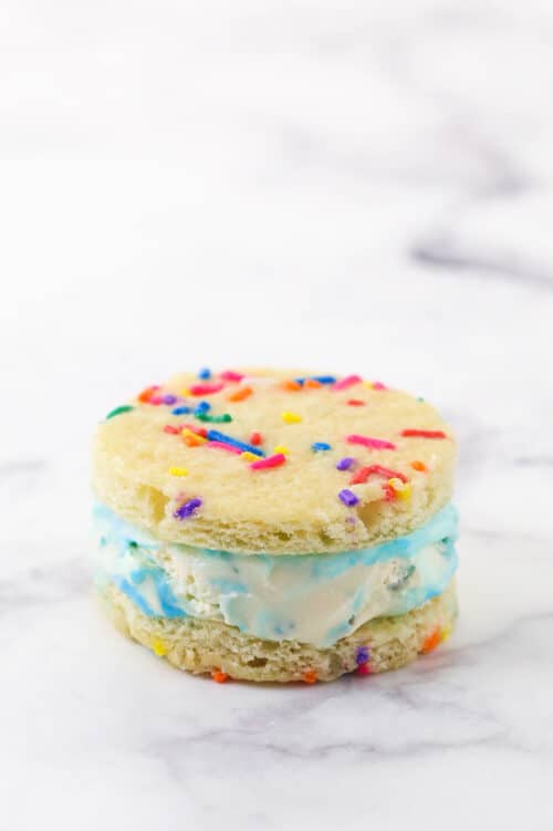 A single cake batter ice cream sandwich on a marble countertop