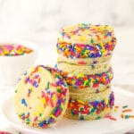 Three ice cream sandwiches piled on top of one another with a fourth one leaning against the stack