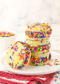 Three ice cream sandwiches piled on top of one another with a fourth one leaning against the stack