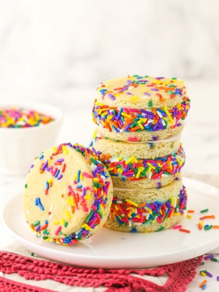 Three ice cream sandwiches piled on top of one another with a fourth one leaning against the stack
