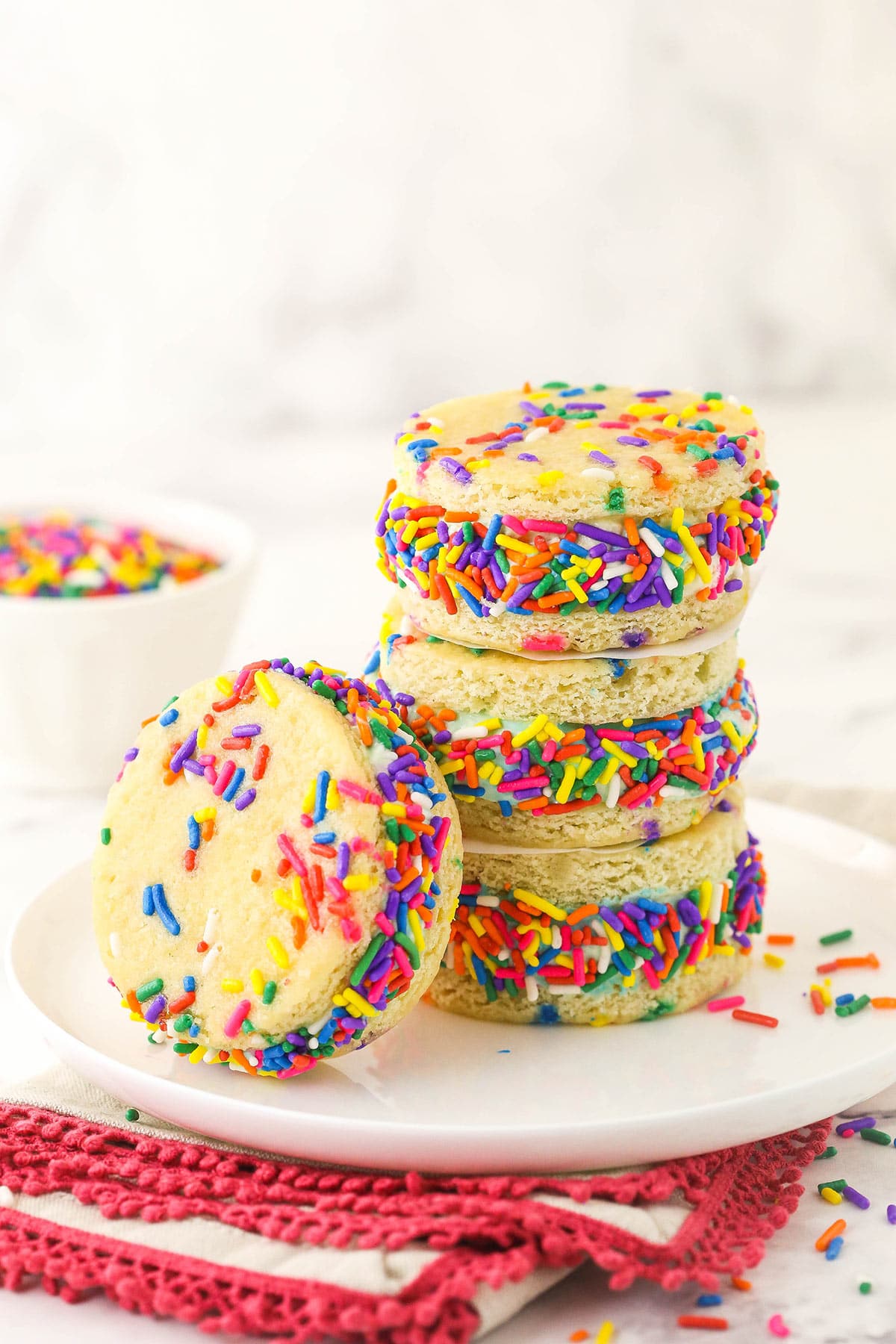 Three ice cream sandwiches piled on top of one another with a fourth one leaning against the stack