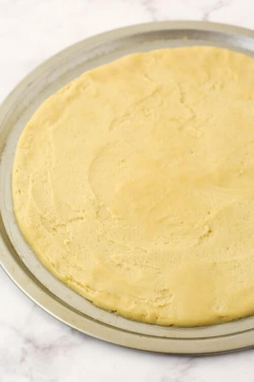 A chilled circle of sugar cookie pizza dough with smoothed edges