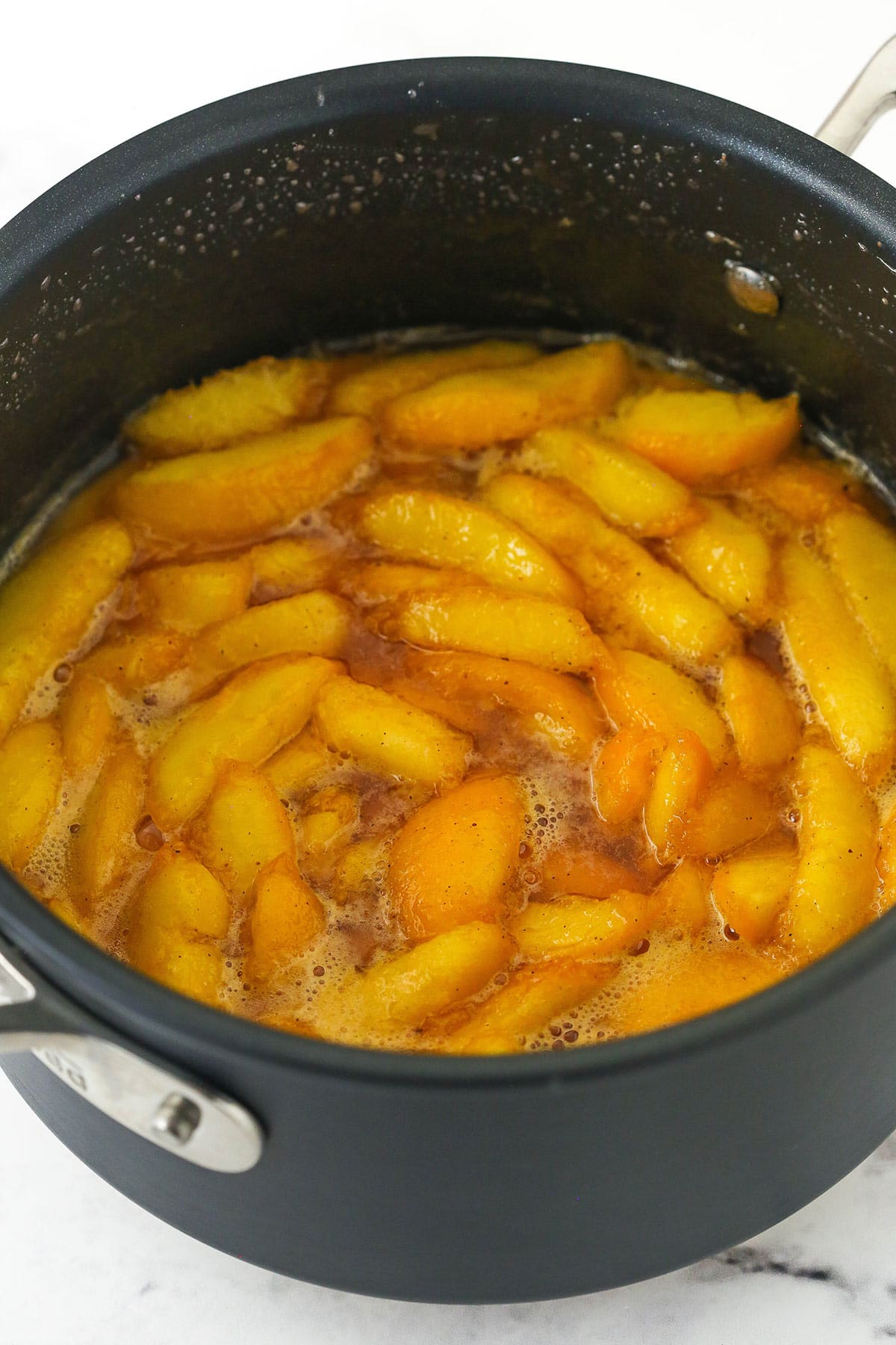 cooked peach filling in a saucepan on marble background