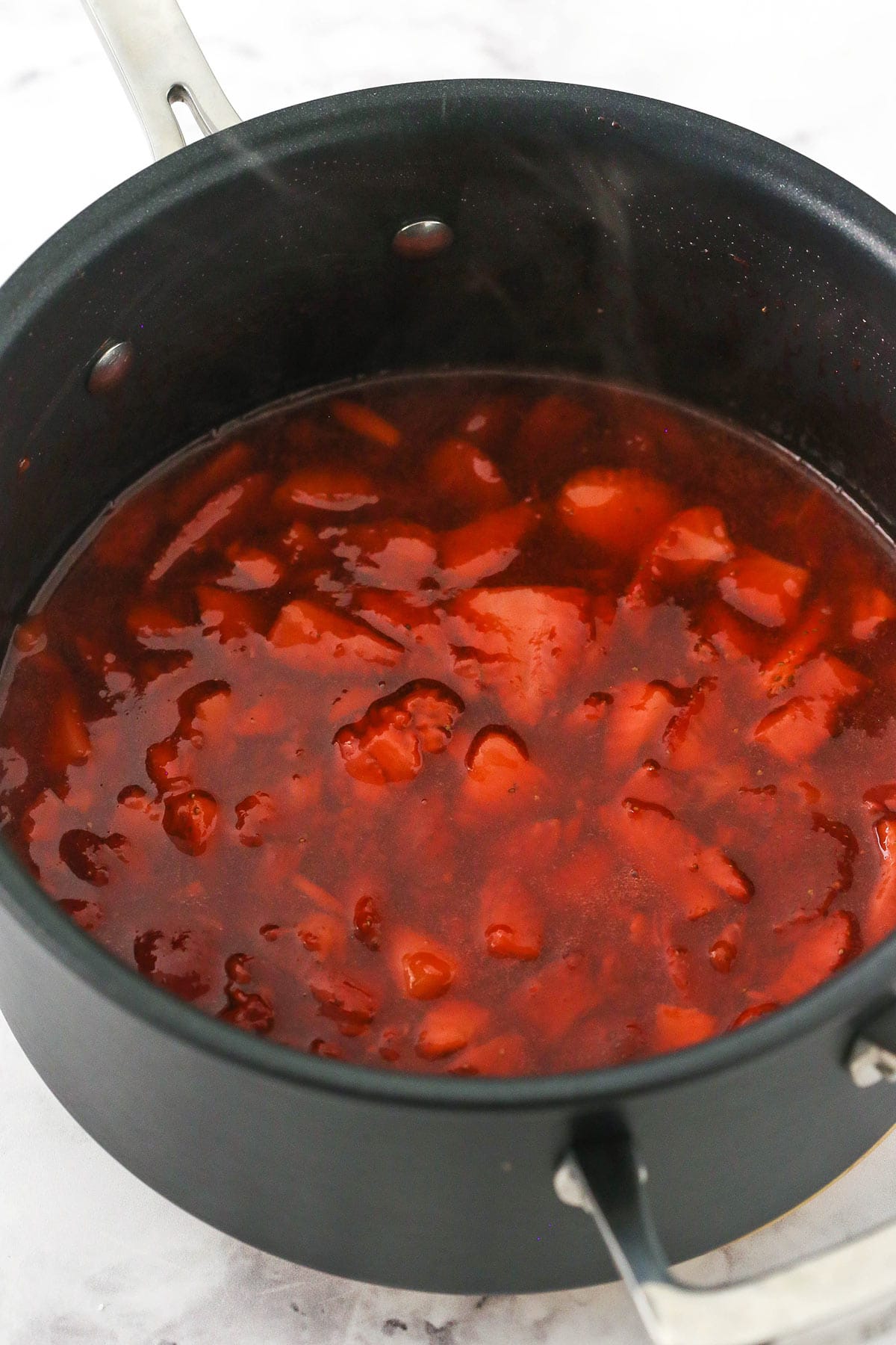hot strawberry sauce cooked in a saucepan