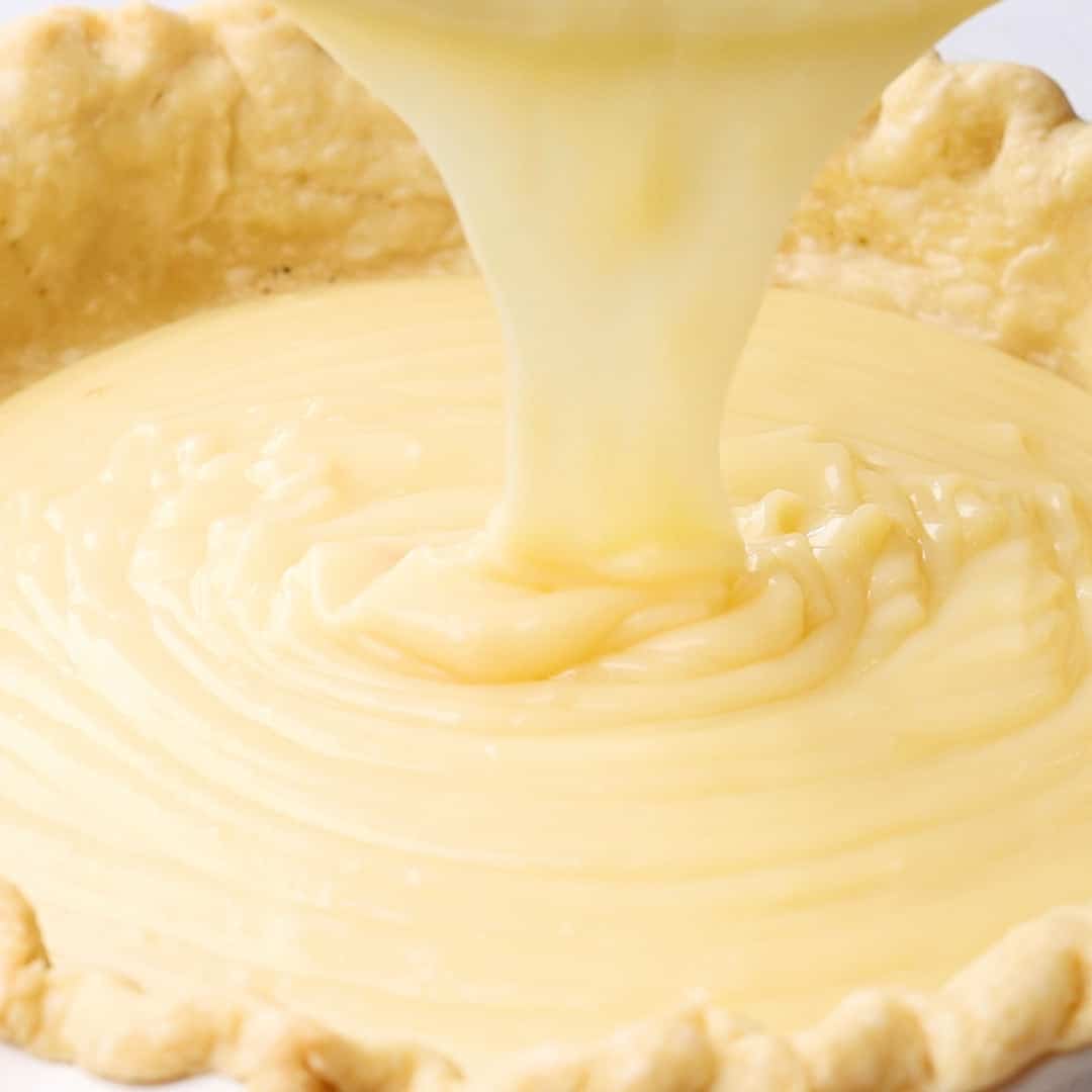 the pie filling being poured into the prepared crust