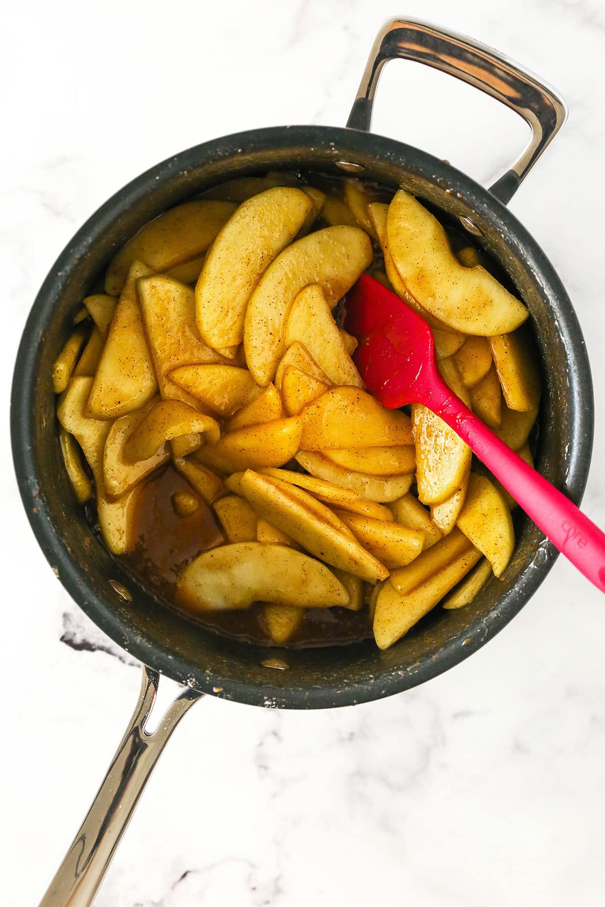 The pre-cooked filling in a pot being stirred by a rubber spatula