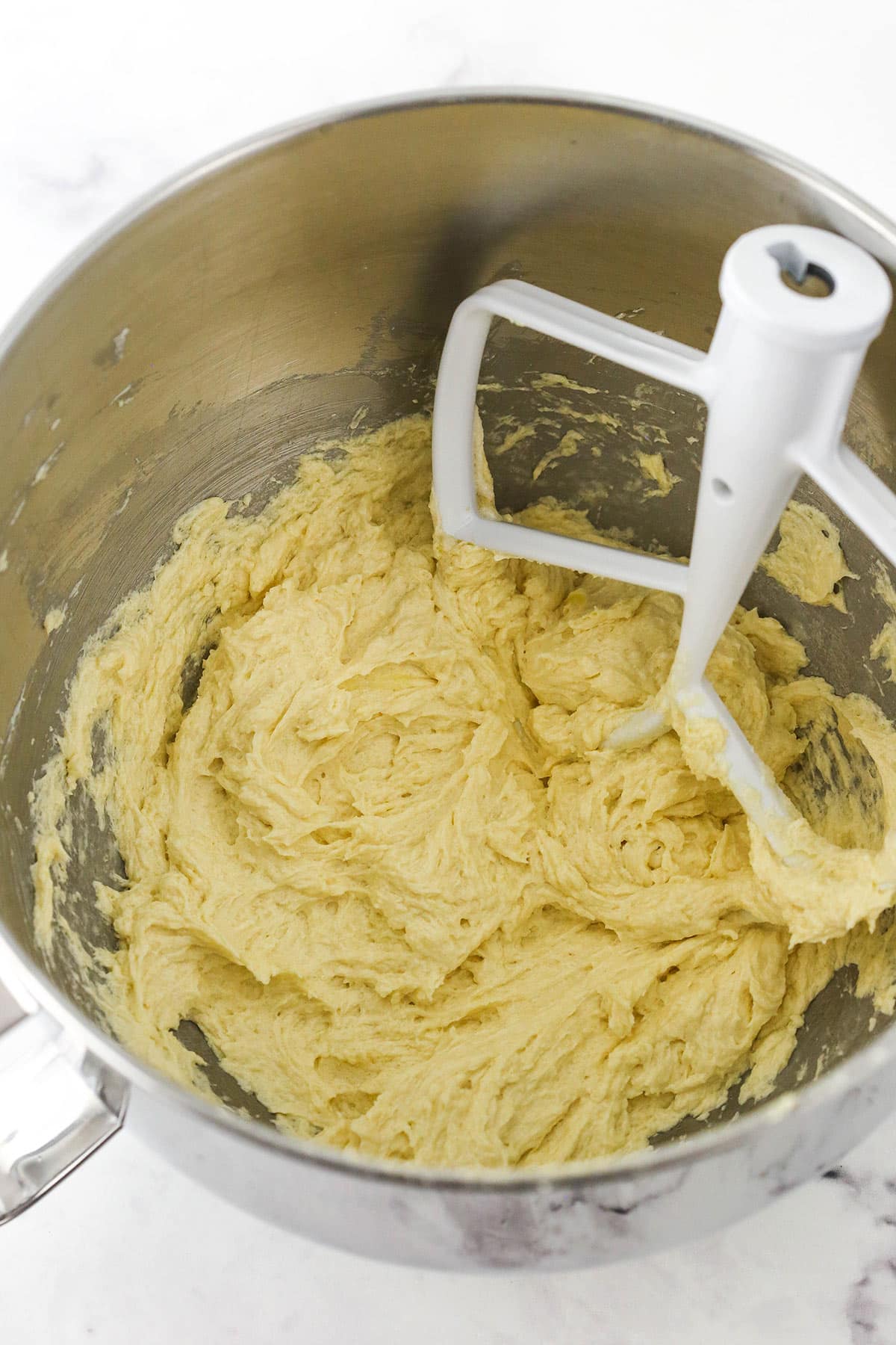 The combined wet ingredients inside of a mixing bowl on a kitchen countertop