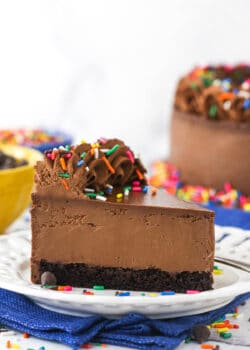 A piece of chocolate cheesecake on a dessert plate on top of a blue kitchen towel