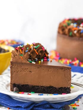 A piece of chocolate cheesecake on a dessert plate on top of a blue kitchen towel