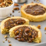 A pecan pie cookie cut in half with the homemade filling oozing out