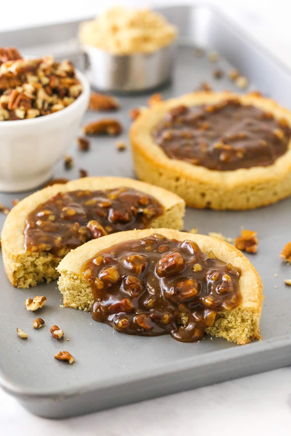 A pecan pie cookie cut in half with the homemade filling oozing out