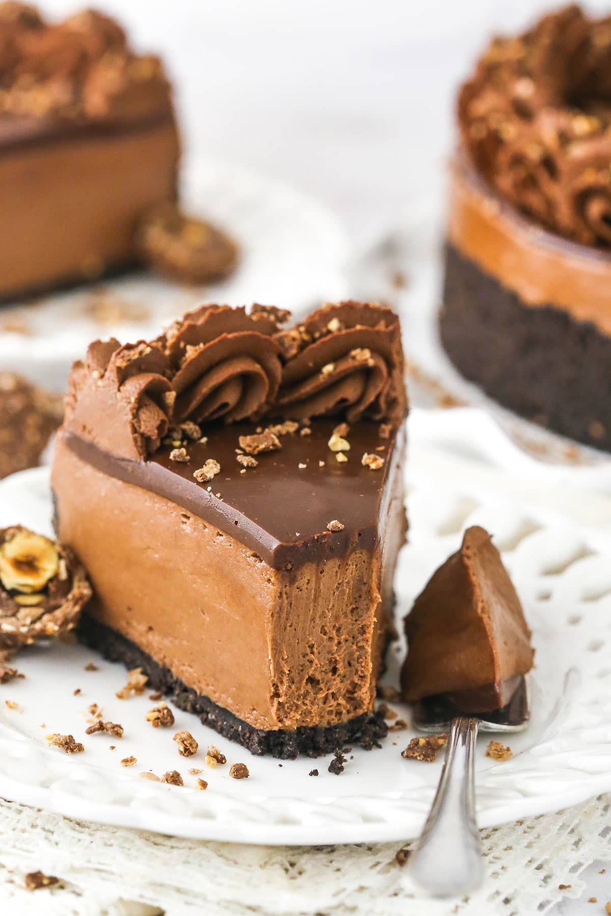 A slice of no bake Nutella cheesecake on a plate with one bite on a fork