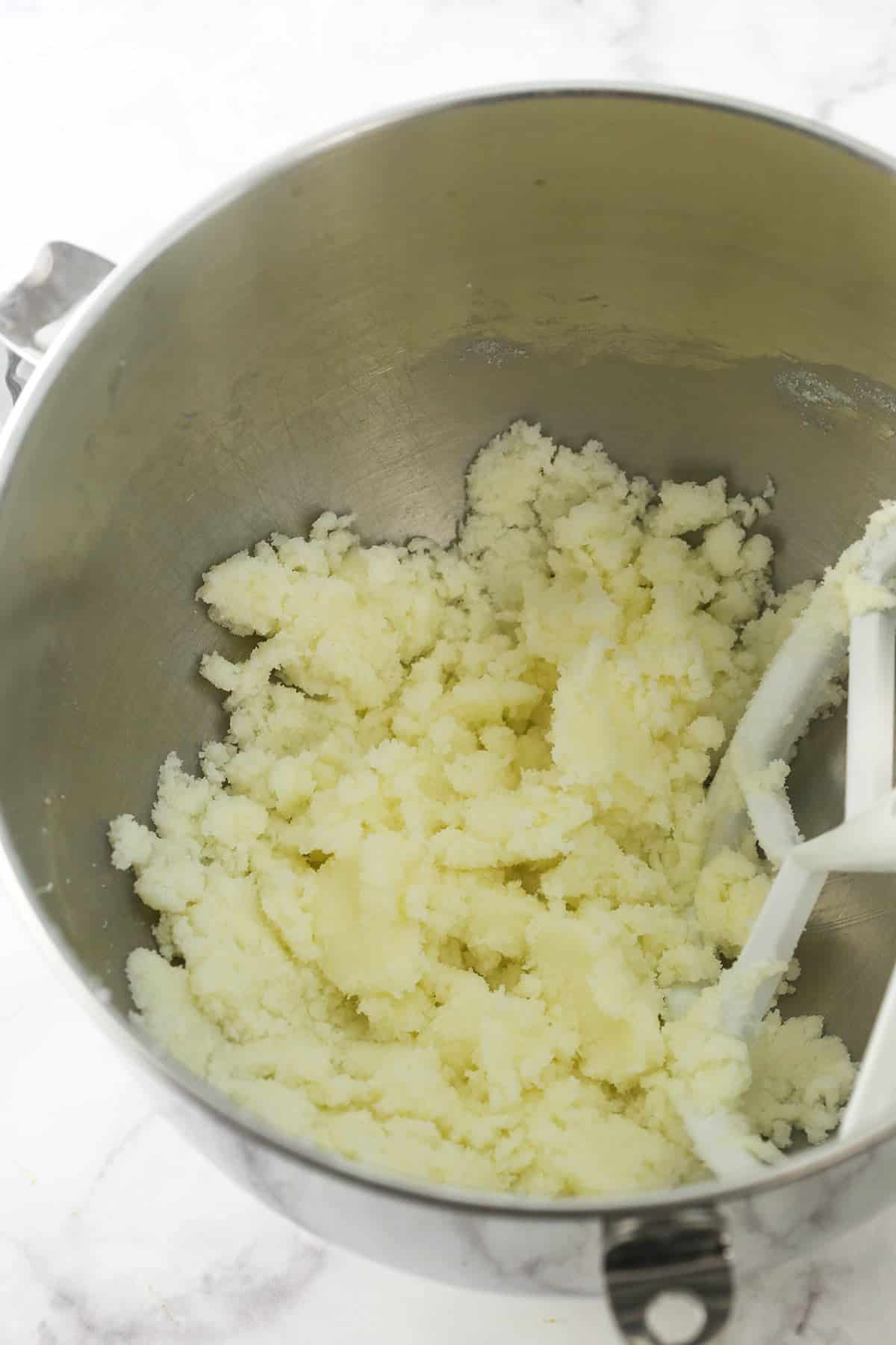 Butter and sugar being mixed in a large metal bowl