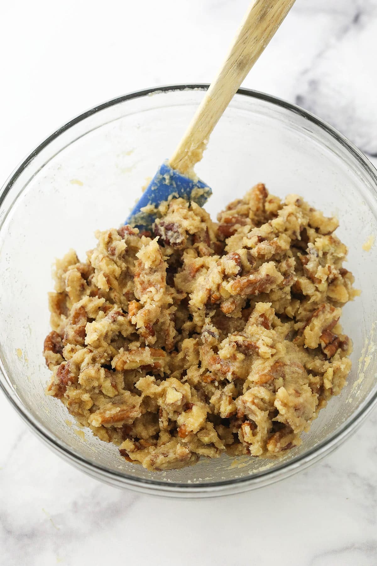 The pecan praline filling in a glass mixing bowl on a marble surface