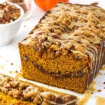 Half a loaf of praline pumpkin bread with a few individual slices in the foreground