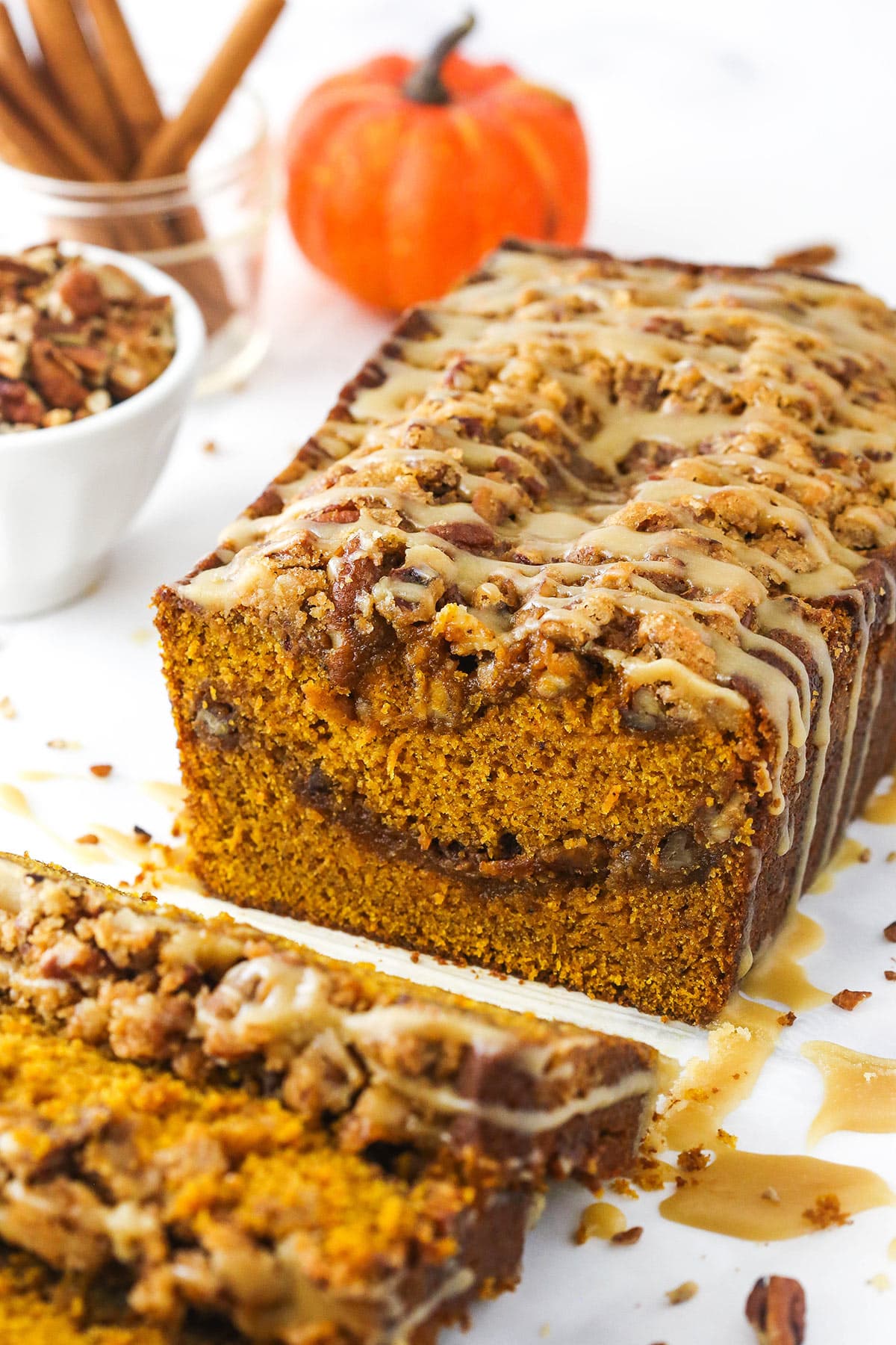 Half a loaf of praline pumpkin bread with a few individual slices in the foreground