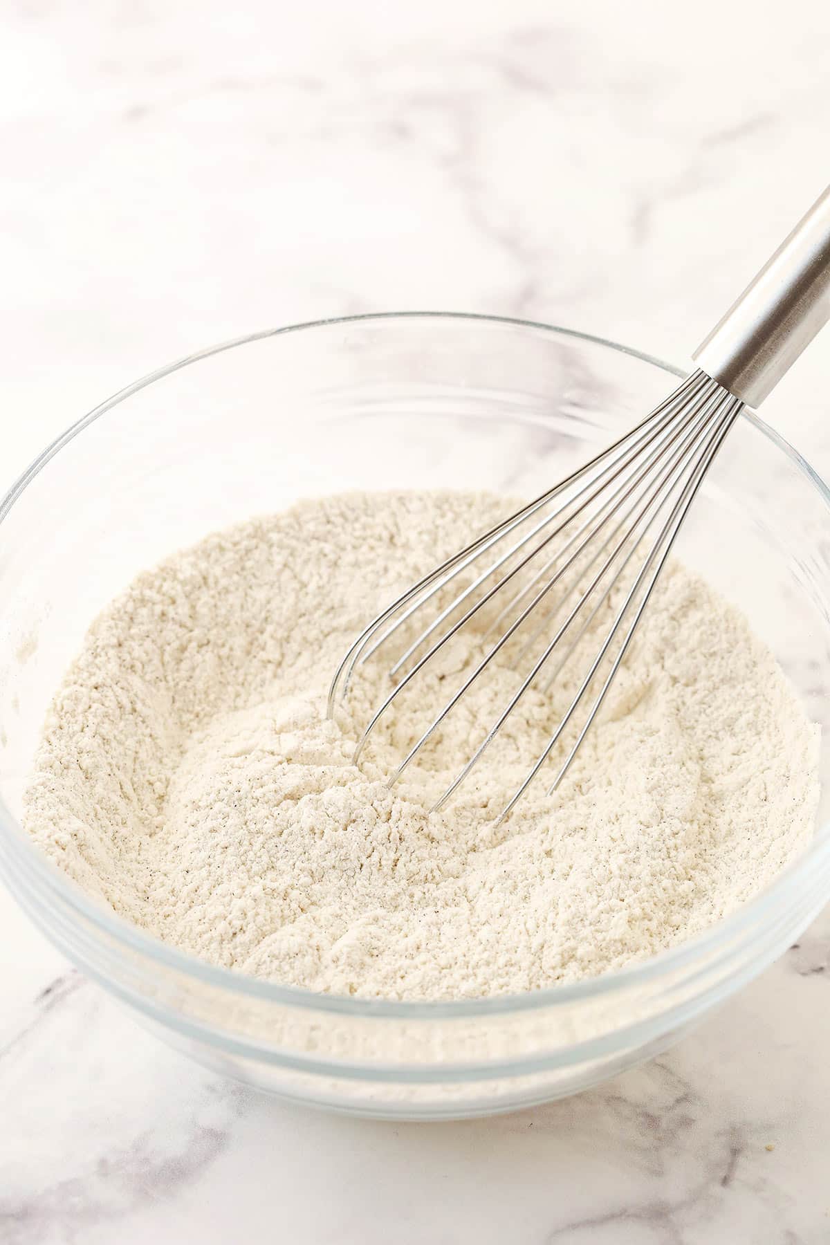 The combined dry ingredients inside of a bowl on a marble surface