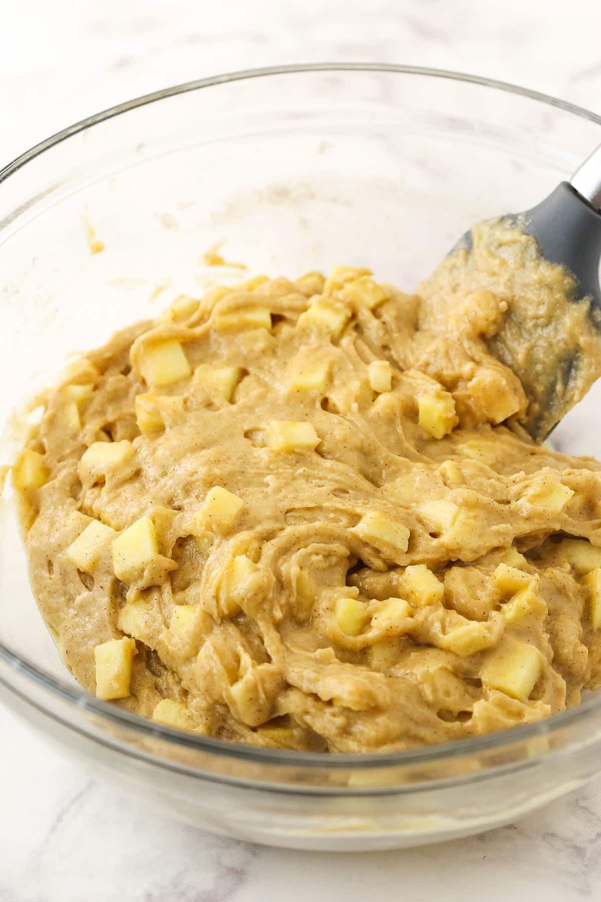 The finished batter inside of a large glass mixing bowl