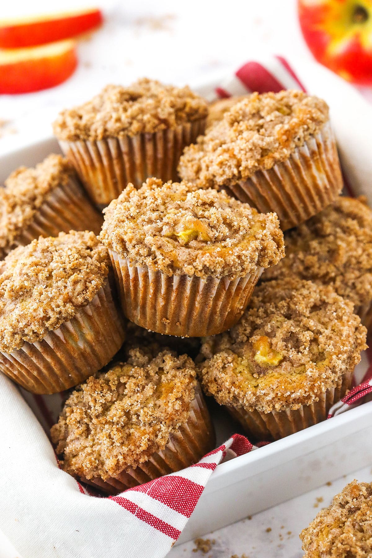 cinnamon apple streusel muffins piled in a white dish
