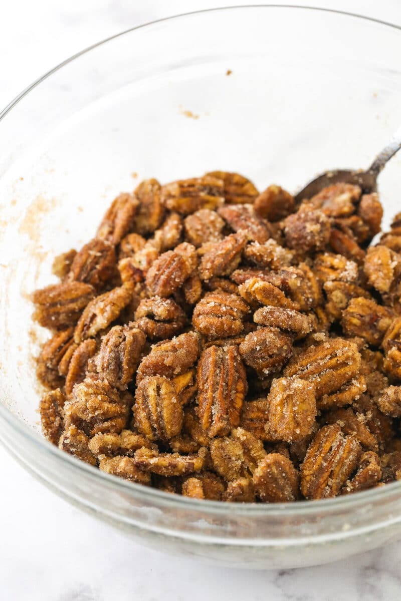 A bowl of pecans coated evenly in both the egg white and sugar mixtures.