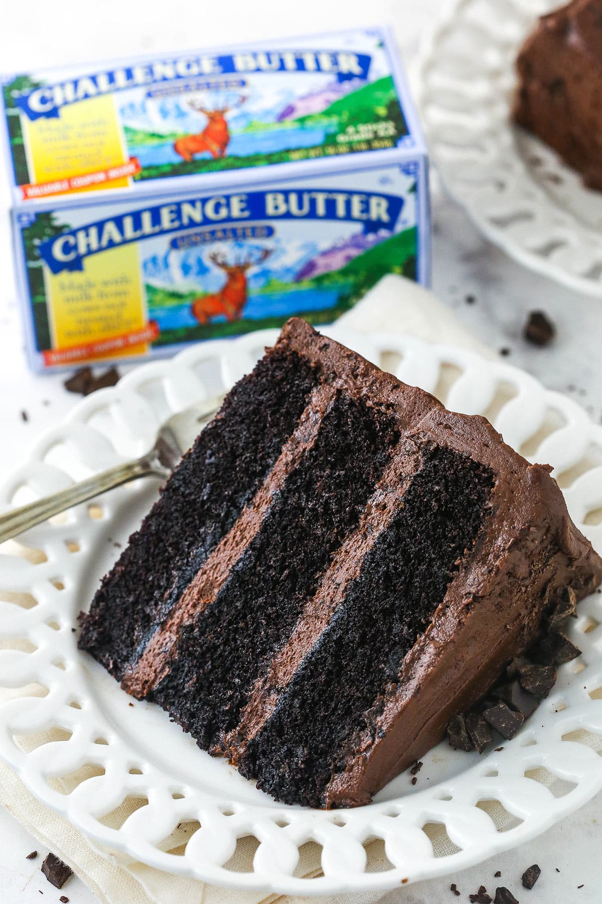 slice of devils food cake with challenge butter in background