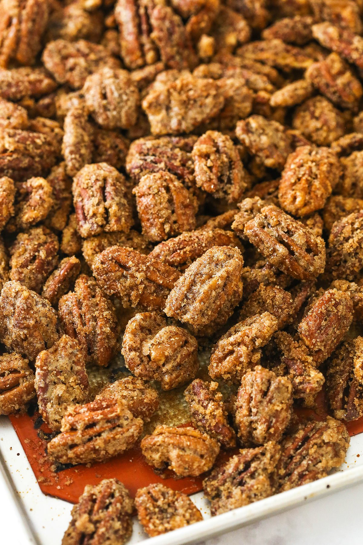 Sugared nuts on a metal baking sheet lined with a Silpat liner