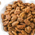 A bowl of cinnamon sugar pecans on a kitchen countertop