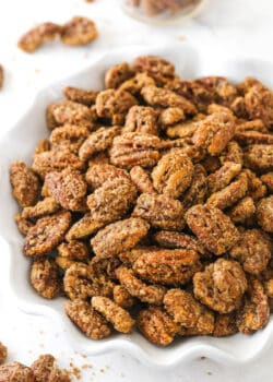 A bowl of cinnamon sugar pecans on a kitchen countertop