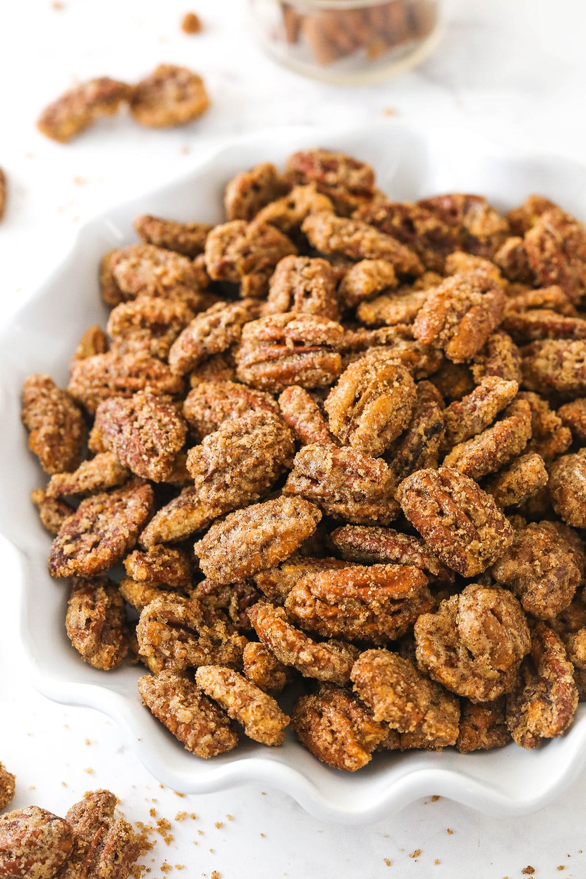 A bowl of cinnamon sugar pecans on a kitchen countertop.