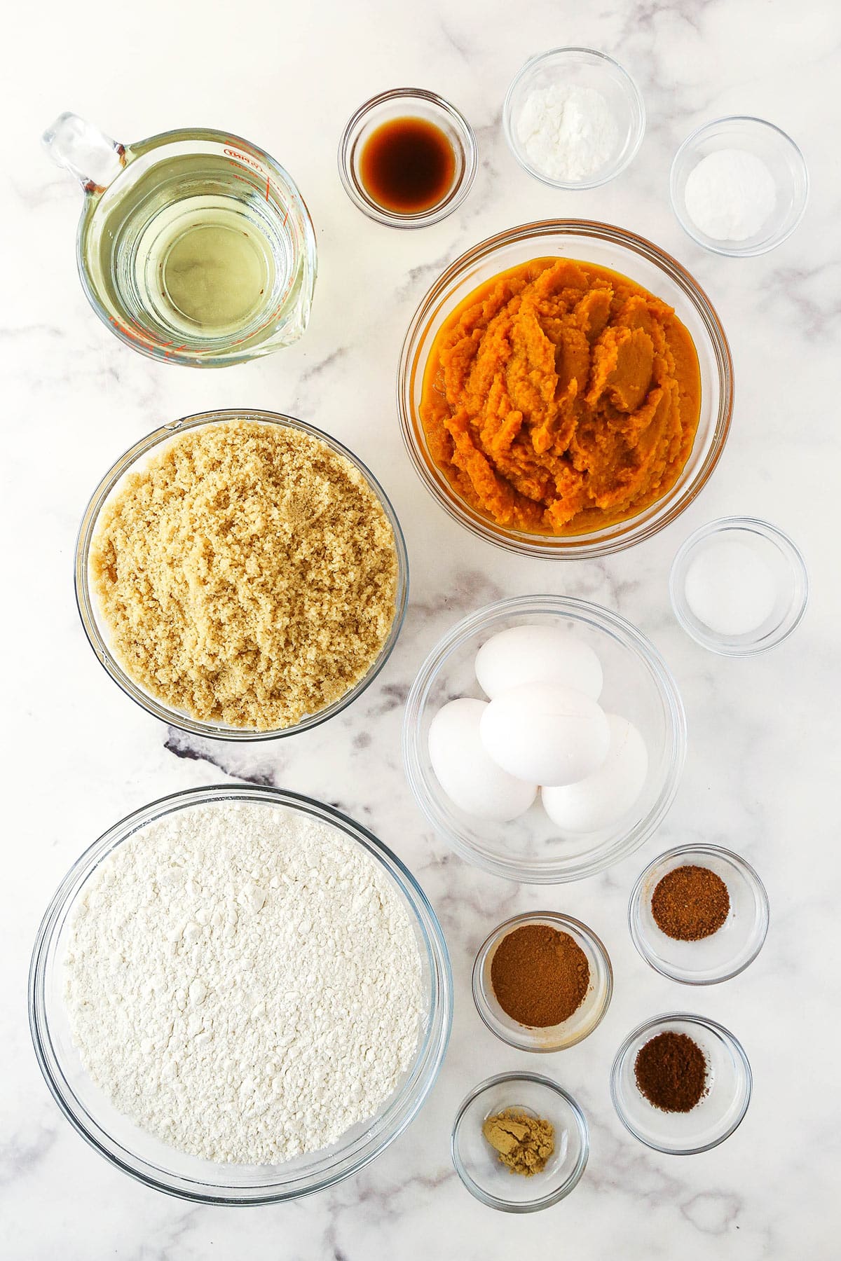 Eggs, cinnamon, nutmeg, ginger and the rest of the ingredients arranged neatly on a kitchen countertop