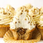 An unwrapped pecan pie cupcake with a bite taken out of it to reveal the gooey filling