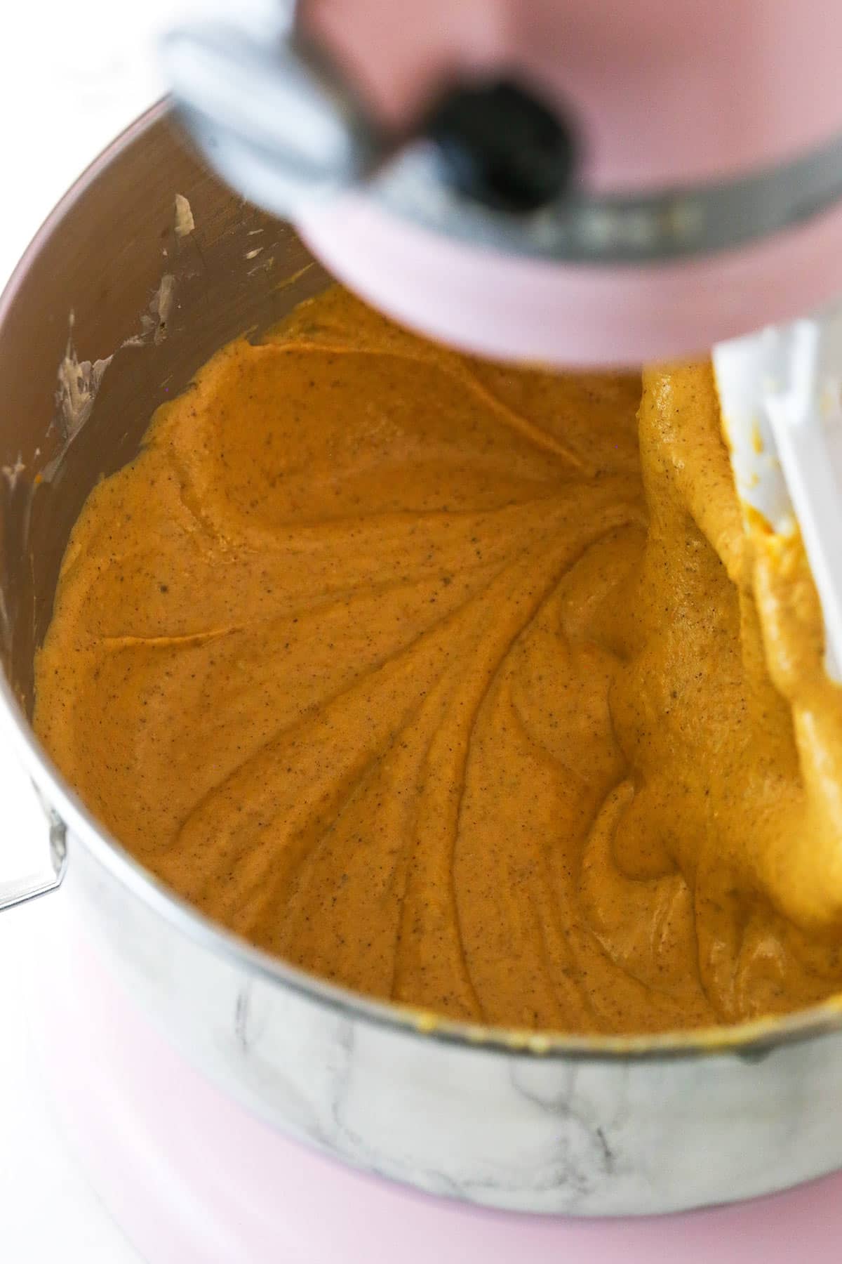 The cream cheese mixture being combined with the puree, sour cream, vanilla and spices in an electric mixing bowl