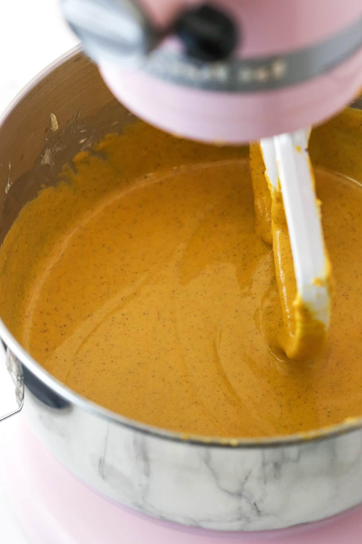 An electric mixer combining all of the filling ingredients in a large metal bowl