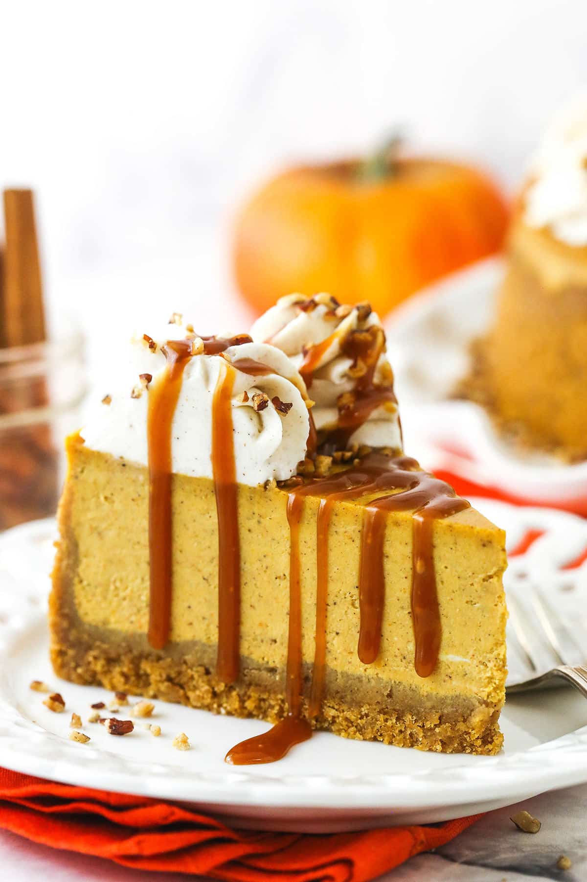 A slice of pumpkin cheesecake topped with a drizzle of homemade caramel sauce