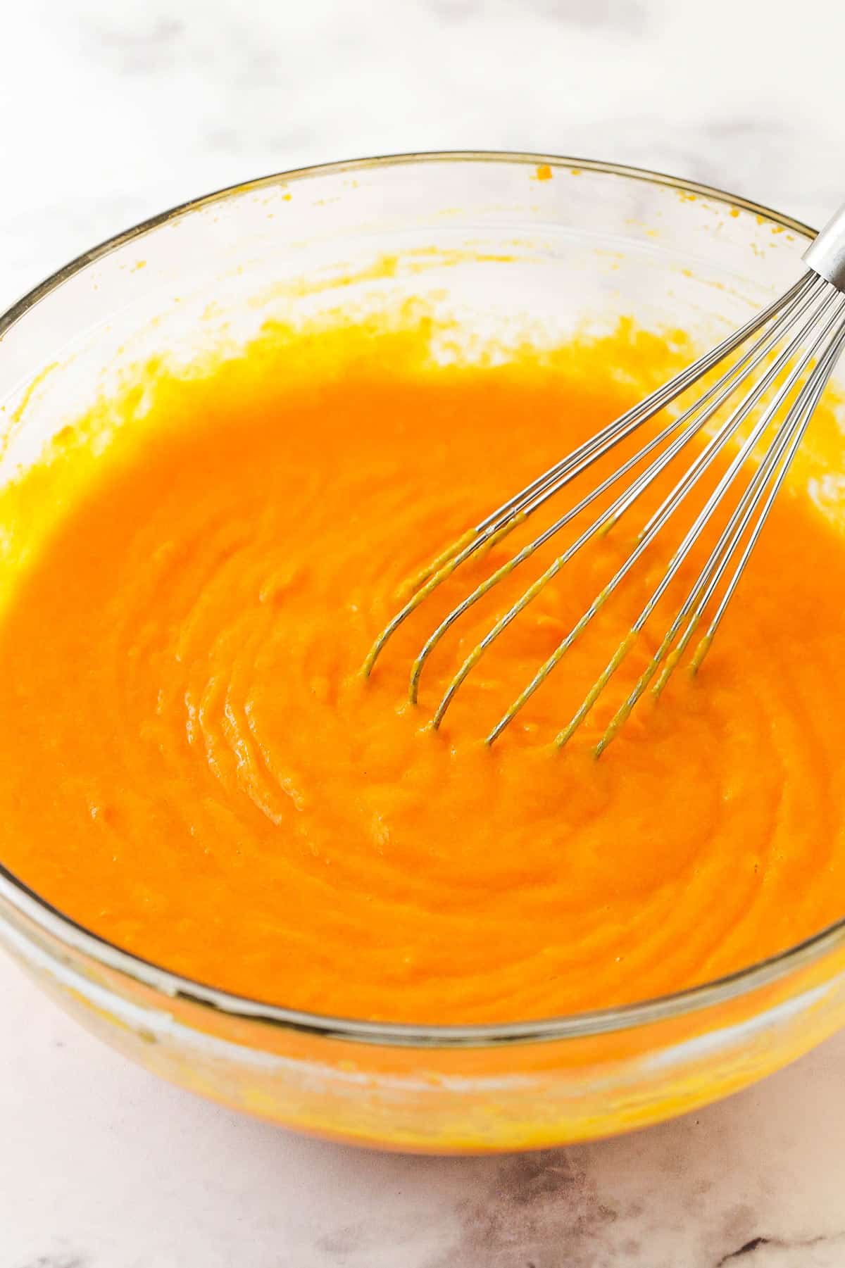 The batter being whisked in a mixing bowl before the dry ingredients have been added