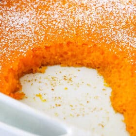 A carrot souffle in a casserole dish with a few servings missing