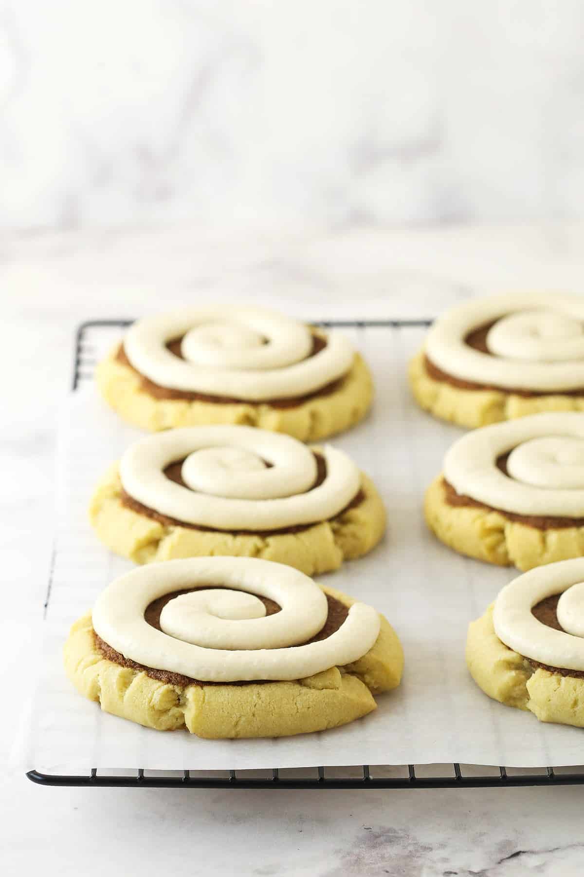 Copycat Crumbl cookies on a lined cooling rack on top of a marble surface