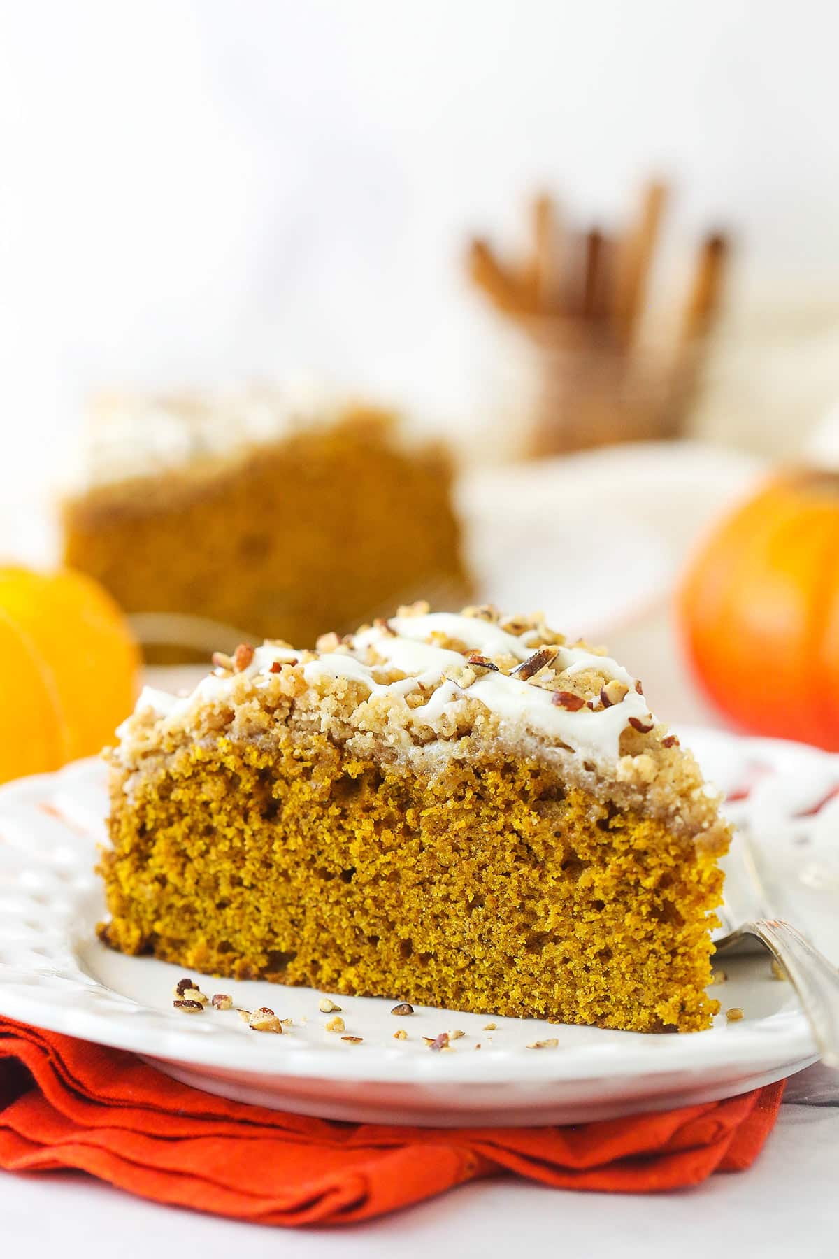 A piece of homemade coffee cake on a plate with cinnamon streusel and glaze on top.